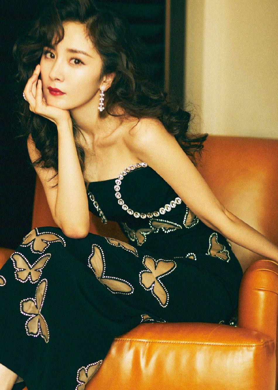 Dương Mịch để kiểu tóc xoăn rẽ ngôi, trang điểm nhẹ nhàng nhấn vào màu môi đỏ. Trang sức đi kèm là bông tai xương cá và nhẫn kim cương "khủng".