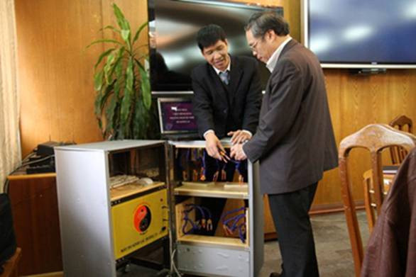 Ông Đinh Lai Thịnh (bên trái) giới thiệu máy Đo Kinh lạc Model TS - 2010 tại một hội thảo khoa học. Ảnh: Tư liệu. 
