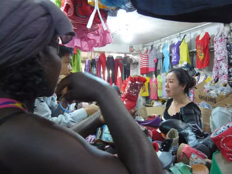 Chị Hà Thị Hương đang bán quần áo cho người Angola