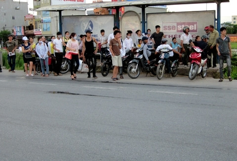 Xe ôm thản nhiên nằm ngả ngớn trên xe để chờ khách ngay trong phạm vi nhà chờ của xe buýt