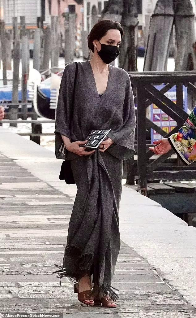 Sau đó, vợ cũ Brad Pitt tách các con để thăm thú phố xá cùng một người bạn. Nữ diễn viên 46 tuổi mặc chiếc váy xám rộng phủ kín người từ cổ đến mắt cá chân, chỉ lộ phần xương quai xanh gầy gò.