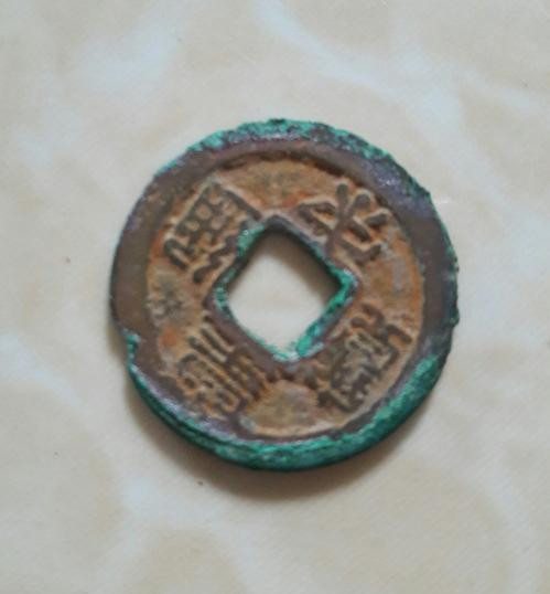 Một đồng tiền cổ nằm trong hũ tiền cổ mà hai ông Nguyễn Quốc Trị và Nguyễn Đình Vương phát hiện, trục vớt được ở bên bờ sông Hiếu.