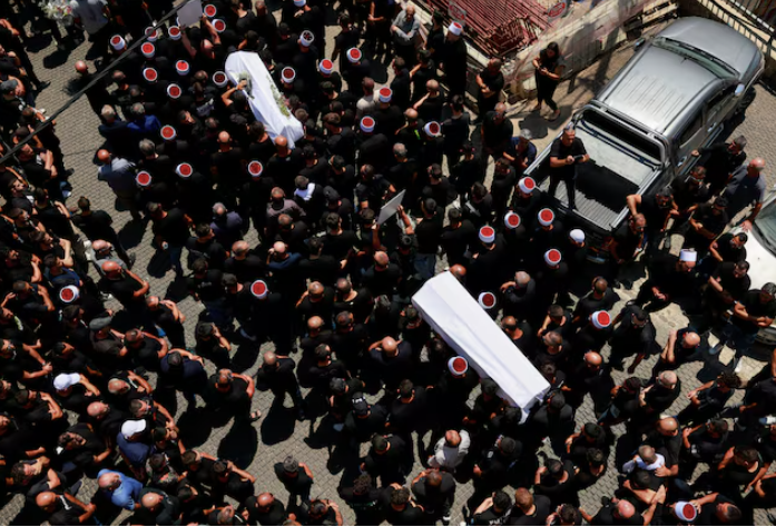 Lễ tang những đứa trẻ thiệt mạng trên sân bóng khi Cao nguyên Golan bị tấn công ngày 27/7. (Ảnh: Reuters) Lễ tang những đứa trẻ thiệt mạng trên sân bóng khi Cao nguyên Golan bị tấn công ngày 27/7. (Ảnh: Reuters)