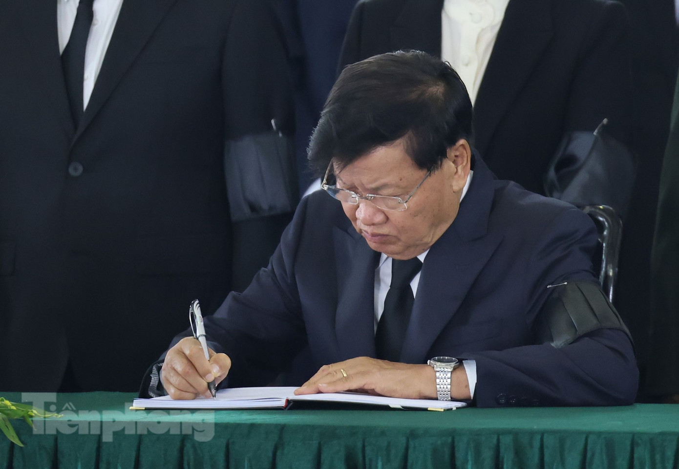 Tổng Bí thư Đảng Nhân dân cách mạng Lào (LPRP), Chủ tịch nước Lào Thongloun Sisoulith ghi sổ tang tưởng nhớ Tổng Bí thư Nguyễn Phú Trọng. (Ảnh: Như Ý)