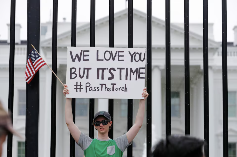 Một thanh niên giơ tấm biển kêu gọi Tổng thống Biden chuyển ngọn đuốc của đảng cho người khác. (Ảnh: Reuters)