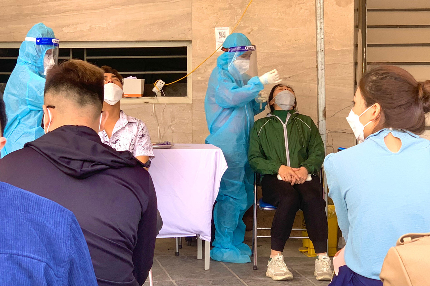 Nhân viên y tế thực hiện xét nghiệm COVID-19 ngay tại vỉa hè trước cổng bệnh viện. Nhân viên y tế thực hiện xét nghiệm COVID-19 ngay tại vỉa hè trước cổng bệnh viện.