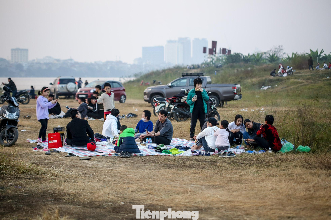 Một nhóm người nhiều lứa tuổi trải bạt ăn uống mà không ai dùng khẩu trang.