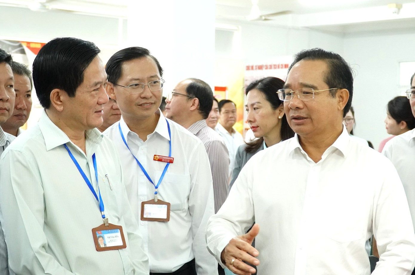 Chủ tịch UBND TPHCM Nguyễn Văn Được (phải) trao đổi với lãnh đạo phường Dĩ An khi đến đây khảo sát trong ngày đầu thực hiện mô hình chính quyền 2 cấp.