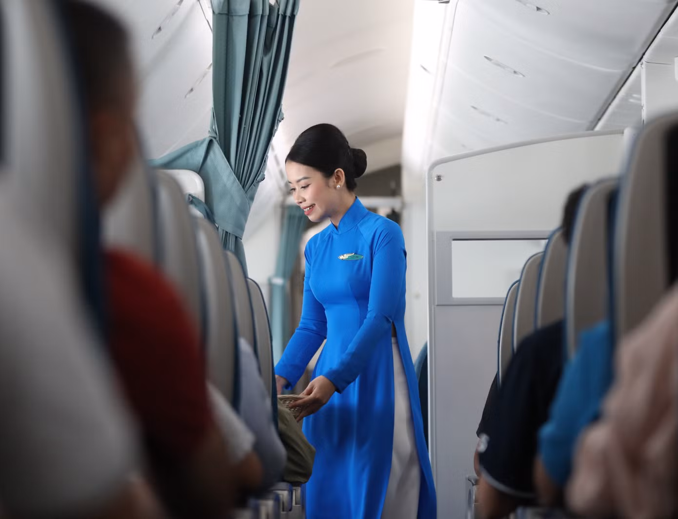 Đầu những năm 1990, lần đầu tiên tà áo dài truyền thống được đưa vào làm đồng phục chính thức, đánh dấu cột mốc quan trọng trong việc định hình bản sắc văn hóa riêng của Vietnam Airlines. Lúc này, bộ đồng phục áo sơ mi và chân váy midi được dùng trên các chuyến bay nội địa còn áo dài xanh được mặc trên các chuyến bay quốc tế, thể hiện được vai trò của hãng Hàng không quốc gia Việt Nam trong việc đưa văn hóa Việt đến gần hơn với bạn bè năm châu. Ảnh: VNA.