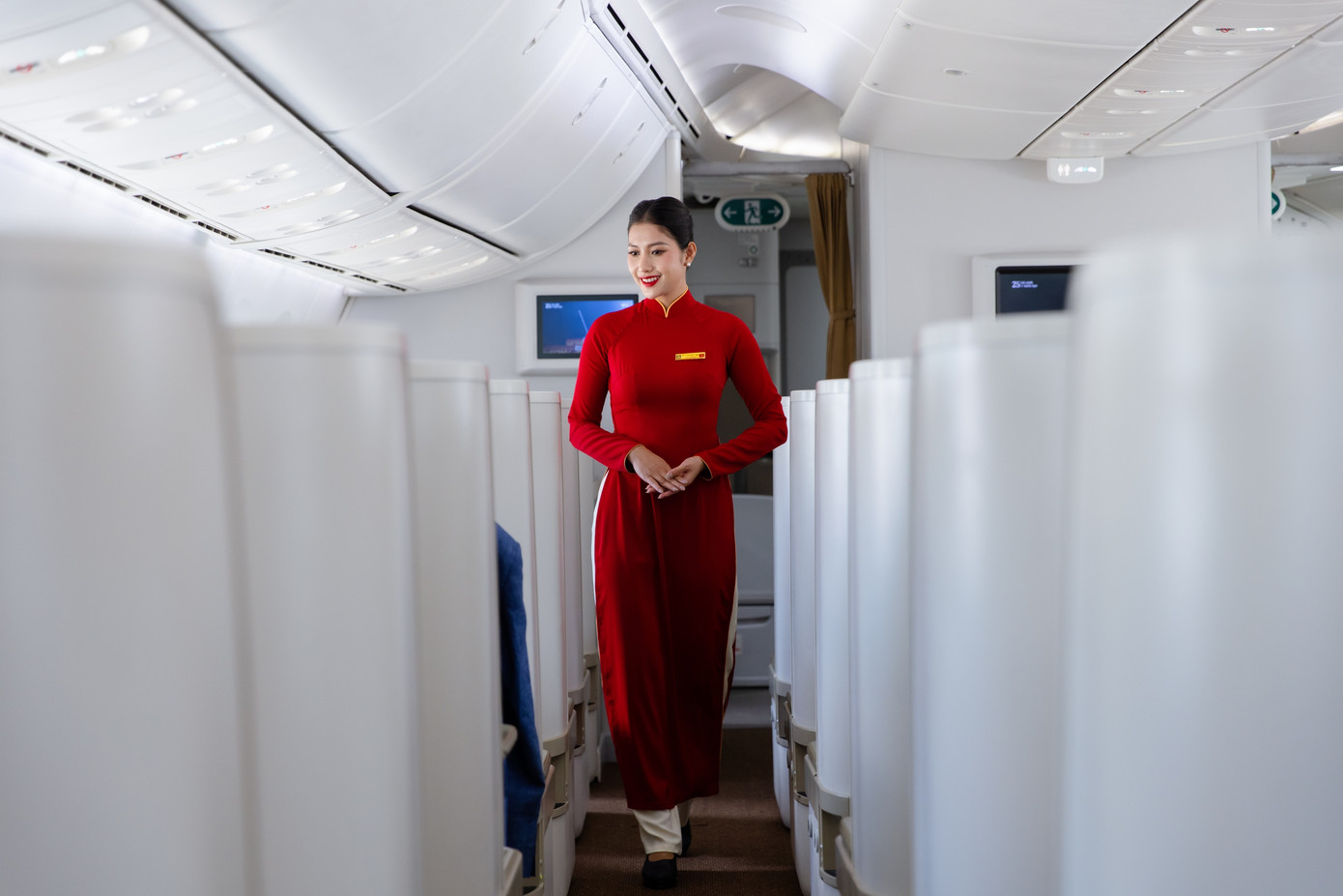 Năm 2000, chiếc áo dài đỏ nhung nổi bật cùng đường viền màu vàng trên cổ áo của tiếp viên hàng không Vietnam Airlines mang đến ấn tượng mạnh với hành khách trong nước và quốc tế. Năm 2010, mẫu trang phục áo dài đỏ của Vietnam Airlines lọt Top 10 trang phục hàng không đẹp nhất thế giới. Ảnh: VNA.