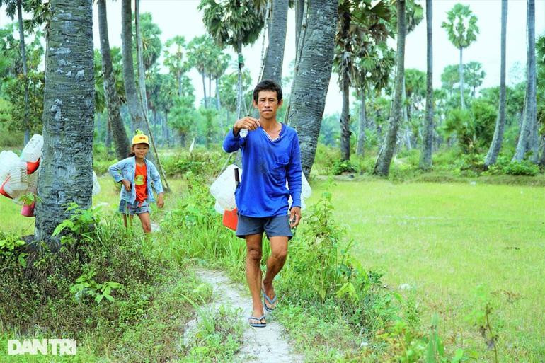 Đứa cháu gái rong ruổi cùng ông ngoại tại cánh đồng thốt nốt (Ảnh: Bảo Kỳ).