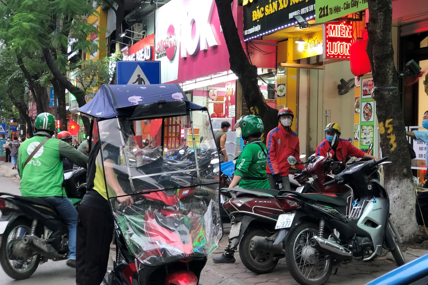 Từ 7 giờ sáng, trước các cửa hàng đồ ăn nhanh trên phố Tô Hiệu (Cầu Giấy, Hà Nội) nhiều shipper đã đứng xếp hàng chờ sẵn để nhận đơn.