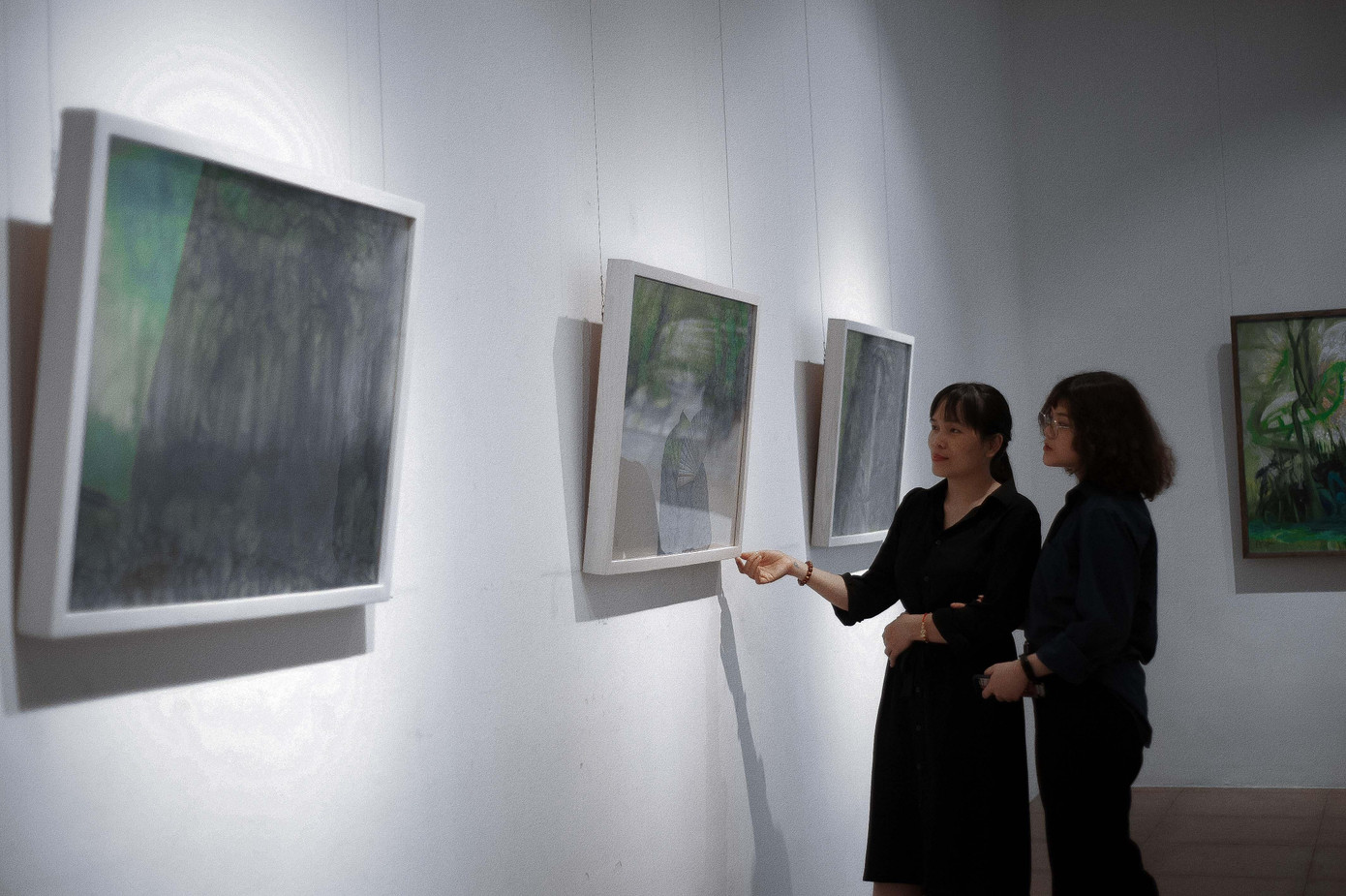 Họa sĩ Phan Minh Bạch cùng khách xem triển lãm