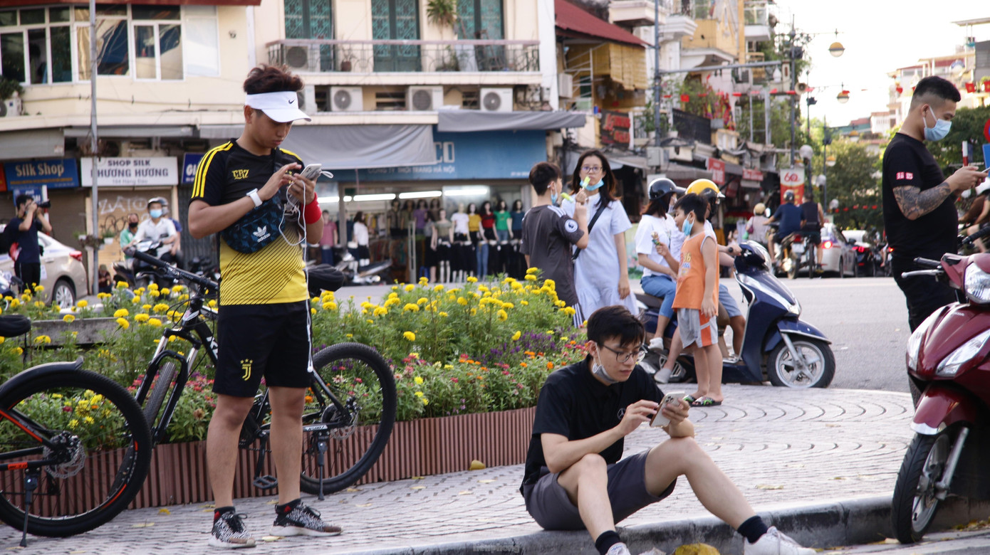 Hình ảnh những người đi bộ, tập thể dục buổi chiều ngồi nghỉ trước đài phun nước quanh hồ. Khẩu trang hời hợt, không đủ giãn cách an toàn.