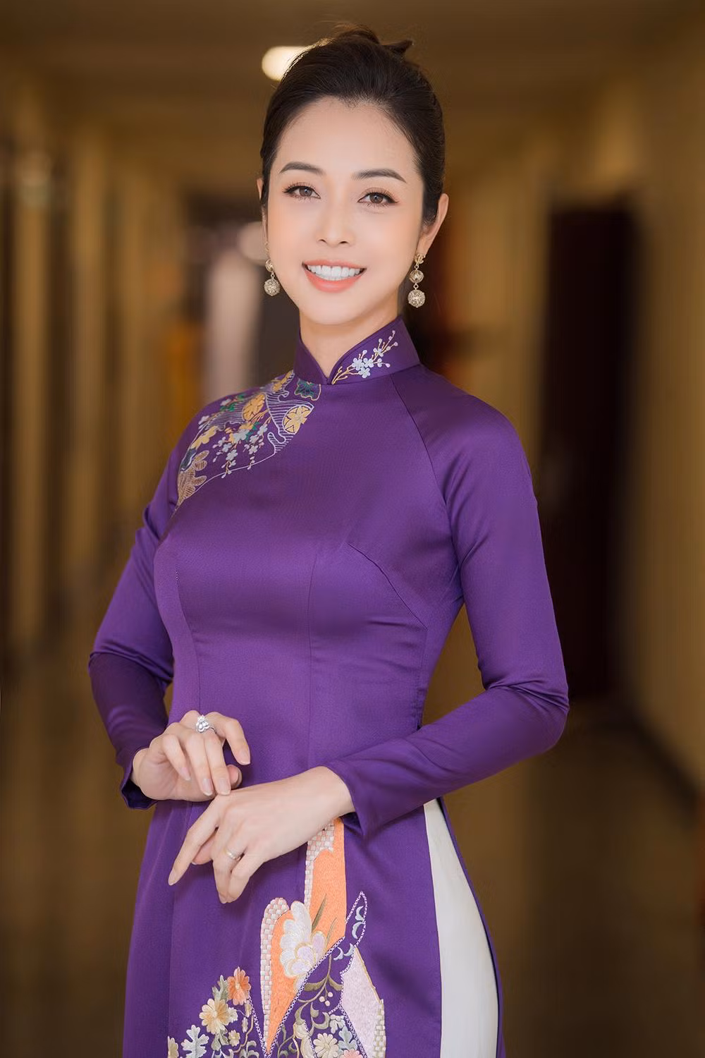 Áo dài tông màu tím đem đến cho hoa hậu 4 con nét nữ tính, kiều diễm nhưng không kém phần trẻ trung.