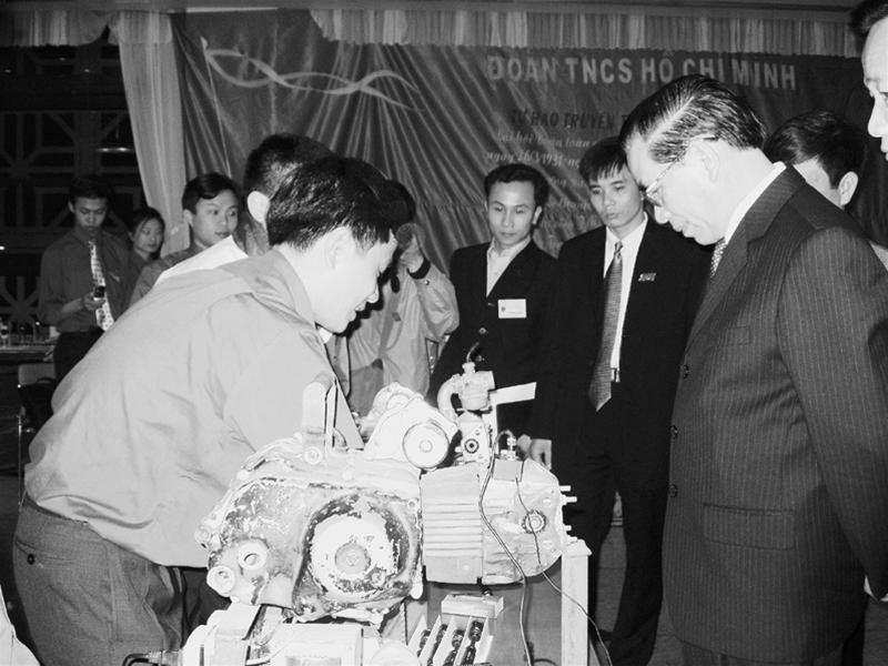 Tiến sĩ Trần Văn Tín giới thiệu với Tổng Bí thư Nông Đức Mạnh bộ tiết kiệm xăng tại triển lãm Hà Nội