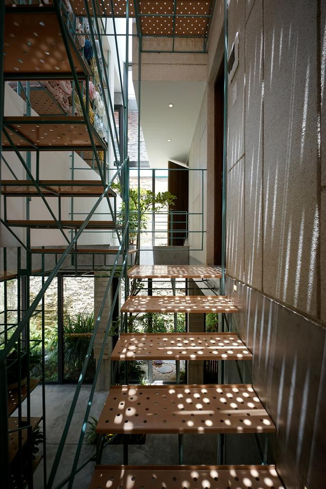 Yếu tố đường biên cũng được cân nhắc để tạo cảm giác lấp lửng, nhập nhằng Trong – Ngoài. Trái với cách sử dụng vật liệu đặc và nặng ở mặt tiền, lõi thang sắt giữa nhà được thiết kế như một yếu tố nhẹ nhàng, mỏng manh, trôi nổi.