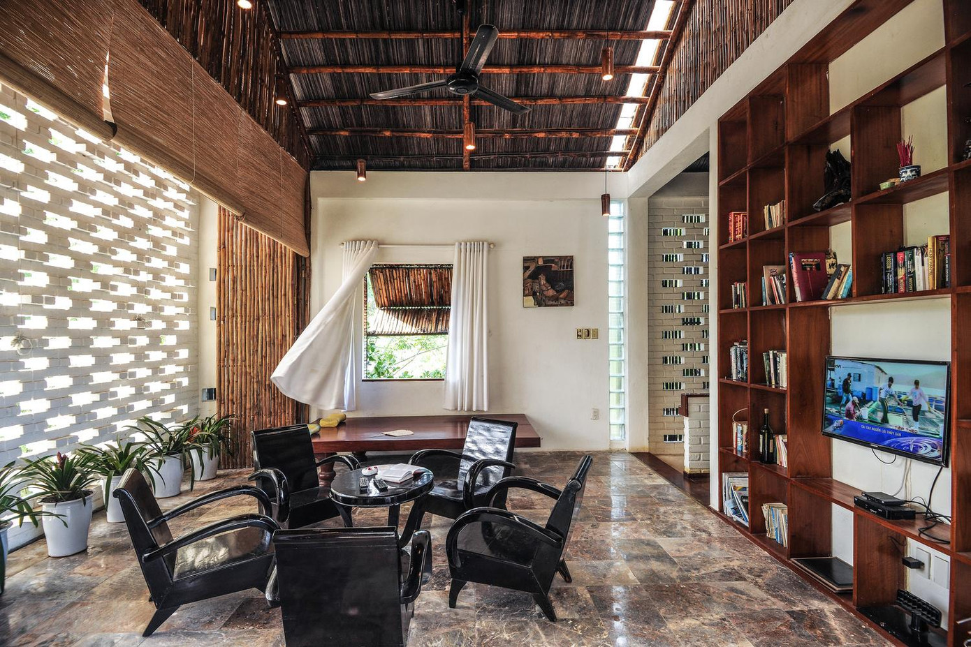 Đầu tiên là cửa sổ không có nhôm kính. Thay vì sử dụng vật liệu công nghiệp, ngôi nhà sử dụng hệ thống cửa chớp xếp bằng tre giúp ngôi nhà luôn tràn ngập ánh sáng tự nhiên và lưu thông không khí. Mặc dù là thiết kế mở nhưng hệ thống cửa chớp vẫn giữ được sự riêng tư và an ninh cho ngôi nhà.