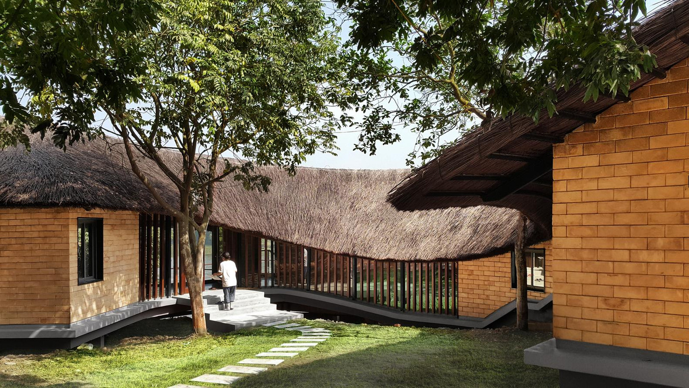 Tường nhà bằng gạch đất nung, chất liệu địa phương quen thuộc giúp cách nhiệt hiệu quả và tiết kiệm chi phí. Đế nhà được chống bởi các cột để tránh ngập úng khi trời mưa.