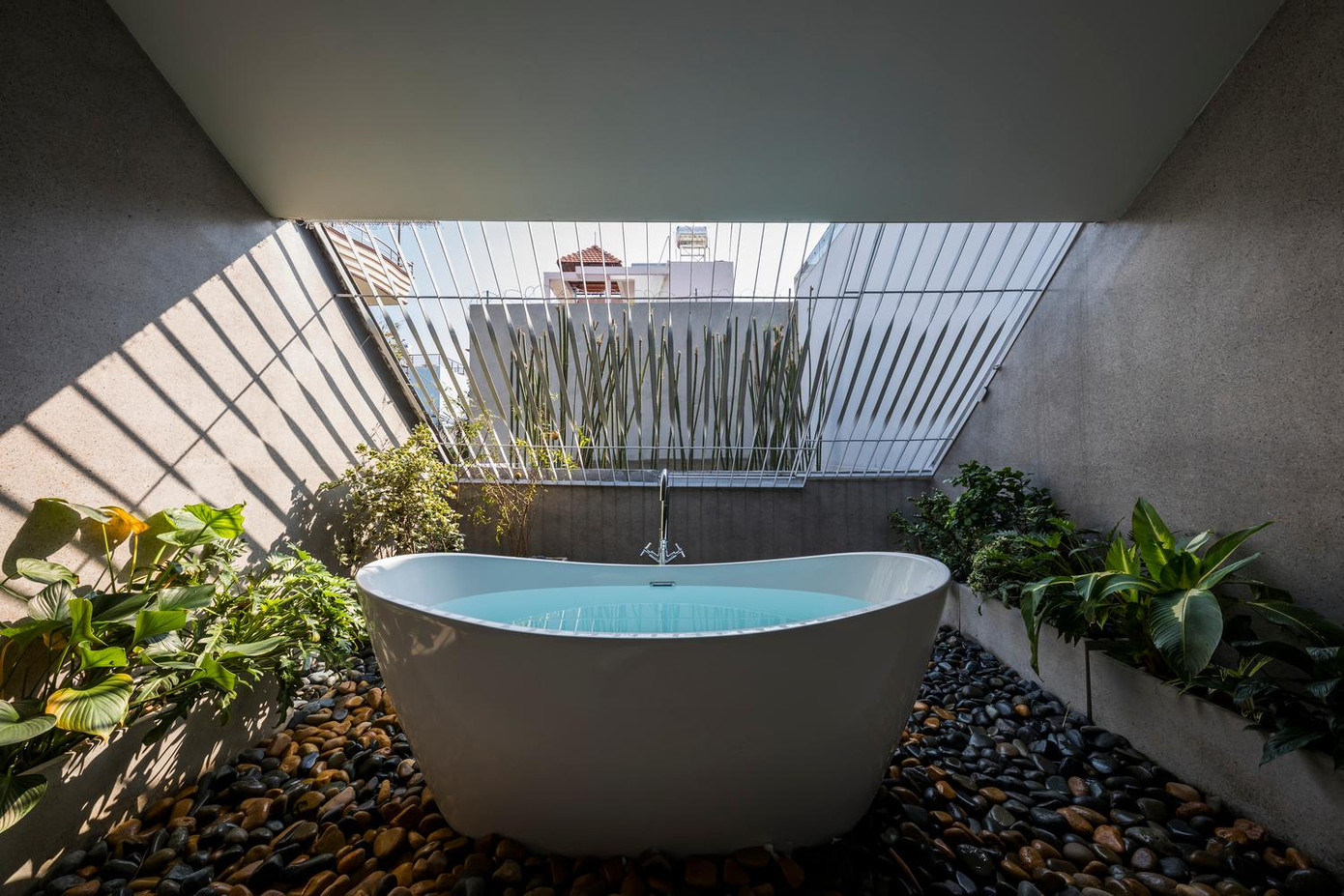 Bồn tắm lộ thiên trải trên lớp đã cuội tạo cảm giác như đang ở spa nghỉ dưỡng.