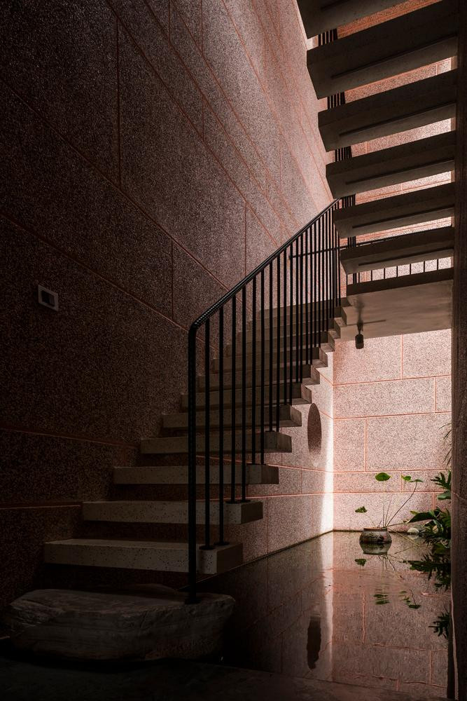 Cầu thang giữa nhà nằm trên một hồ nước nông, giúp không gian luôn mát mẻ và có chiều sâu khi mọi vật chiếu xuống mặt nước.