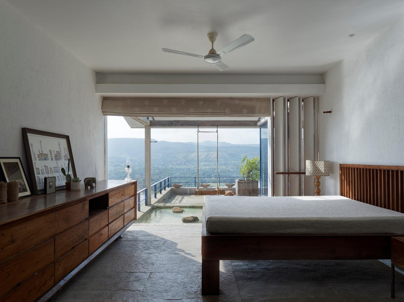 Tầng giữa là không gian sinh hoạt, ăn uống với nhà bếp và phòng ngủ chính cung cấp tầm nhìn 180 độ ra hồ nước và những ngọn đồi phía sau.