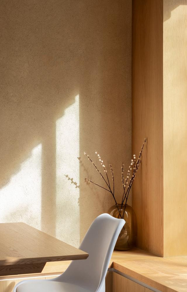 Bức tường phía sau của phòng ăn được hoàn thiện bằng thạch cao đất sét tự nhiên có tông màu đất ấm áp giống với màu của tấm ốp gỗ sồi. Bức tường phía sau của phòng ăn được hoàn thiện bằng thạch cao đất sét tự nhiên có tông màu đất ấm áp giống với màu của tấm ốp gỗ sồi.