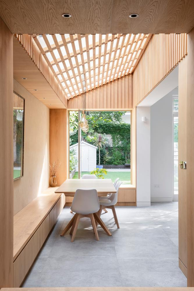 Một chiếc ghế dài chứa đồ chạy dọc khắp phòng ăn và một cửa sổ kính khung lớn giúp người ở có thể ngắm nhìn mọi thứ ngoài khu vườn. Cửa sổ có thể được mở ra kéo vào để kết nối phòng ăn với bên ngoài. Một chiếc ghế dài chứa đồ chạy dọc khắp phòng ăn và một cửa sổ kính khung lớn giúp người ở có thể ngắm nhìn mọi thứ ngoài khu vườn. Cửa sổ có thể được mở ra kéo vào để kết nối phòng ăn với bên ngoài.