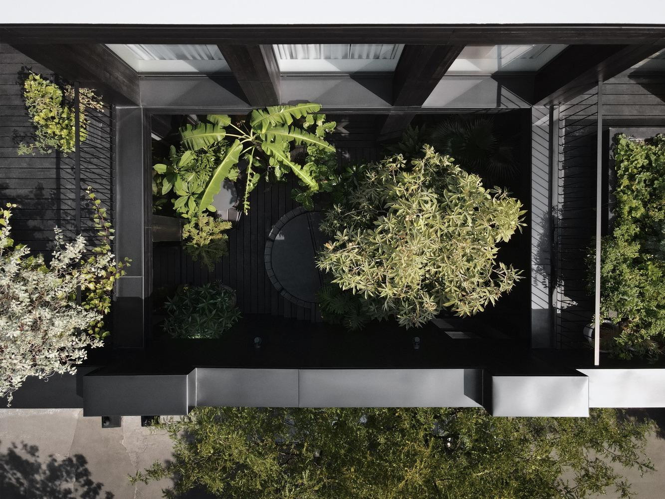 Tầng thứ ba đóng vai trò là khu sinh hoạt chính của tòa nhà và các kiến trúc sư đã khoét rỗng diện tích của nó để tạo ra một sân ngoài trời rộng 200m2 được bao bọc bằng kính. Khoảng sân cũng đóng vai trò phân chia khu vực phòng khách với phòng ngủ chính. Tại sân trong, con người có thể tiếp xúc với các yếu tố thiên nhiên từ nắng, gió từ trên cao và có thảm thực vật tươi tốt. Ở đây còn có một bộ bàn ghế để tiếp khách và bồn ngâm kiểu Nhật Bản. Các kiến trúc sư cho biết, sân trong thực sự làm nổi bật không gian, đồng thời tạo ra một khu vực ngoài trời rất riêng tư cho khách hàng. “Nó cũng cho phép chúng tôi đưa ánh sáng dồi dào vào lõi của tòa nhà”. Tầng thứ ba đóng vai trò là khu sinh hoạt chính của tòa nhà và các kiến trúc sư đã khoét rỗng diện tích của nó để tạo ra một sân ngoài trời rộng 200m2 được bao bọc bằng kính. Khoảng sân cũng đóng vai trò phân chia khu vực phòng khách với phòng ngủ chính. Tại sân trong, con người có thể tiếp xúc với các yếu tố thiên nhiên từ nắng, gió từ trên cao và có thảm thực vật tươi tốt. Ở đây còn có một bộ bàn ghế để tiếp khách và bồn ngâm kiểu Nhật Bản. Các kiến trúc sư cho biết, sân trong thực sự làm nổi bật không gian, đồng thời tạo ra một khu vực ngoài trời rất riêng tư cho khách hàng. “Nó cũng cho phép chúng tôi đưa ánh sáng dồi dào vào lõi của tòa nhà”.