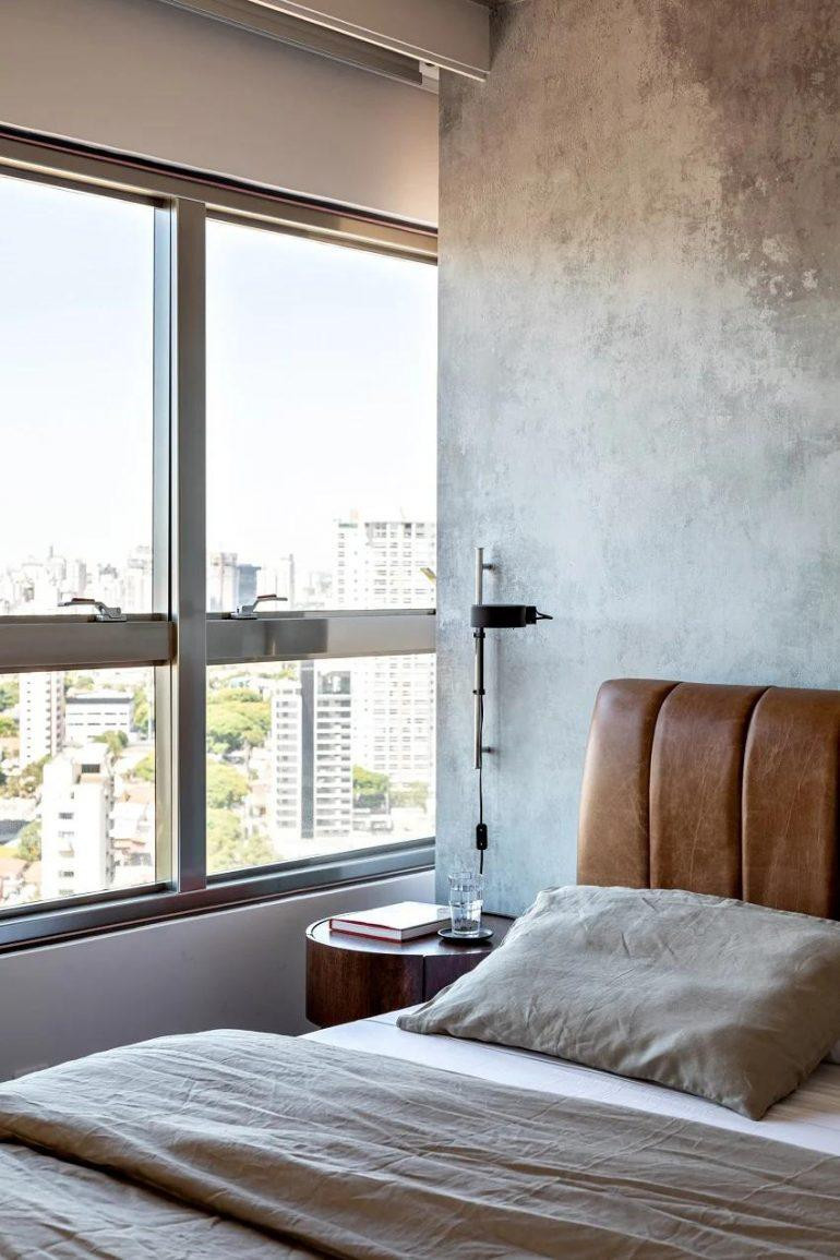 Đầu giường ngủ được bọc da kết hợp với ghế bành bằng nhung màu xanh lá cây giúp không gian toàn bê tông trở nên ấm áp hơn. Đầu giường ngủ được bọc da kết hợp với ghế bành bằng nhung màu xanh lá cây giúp không gian toàn bê tông trở nên ấm áp hơn.