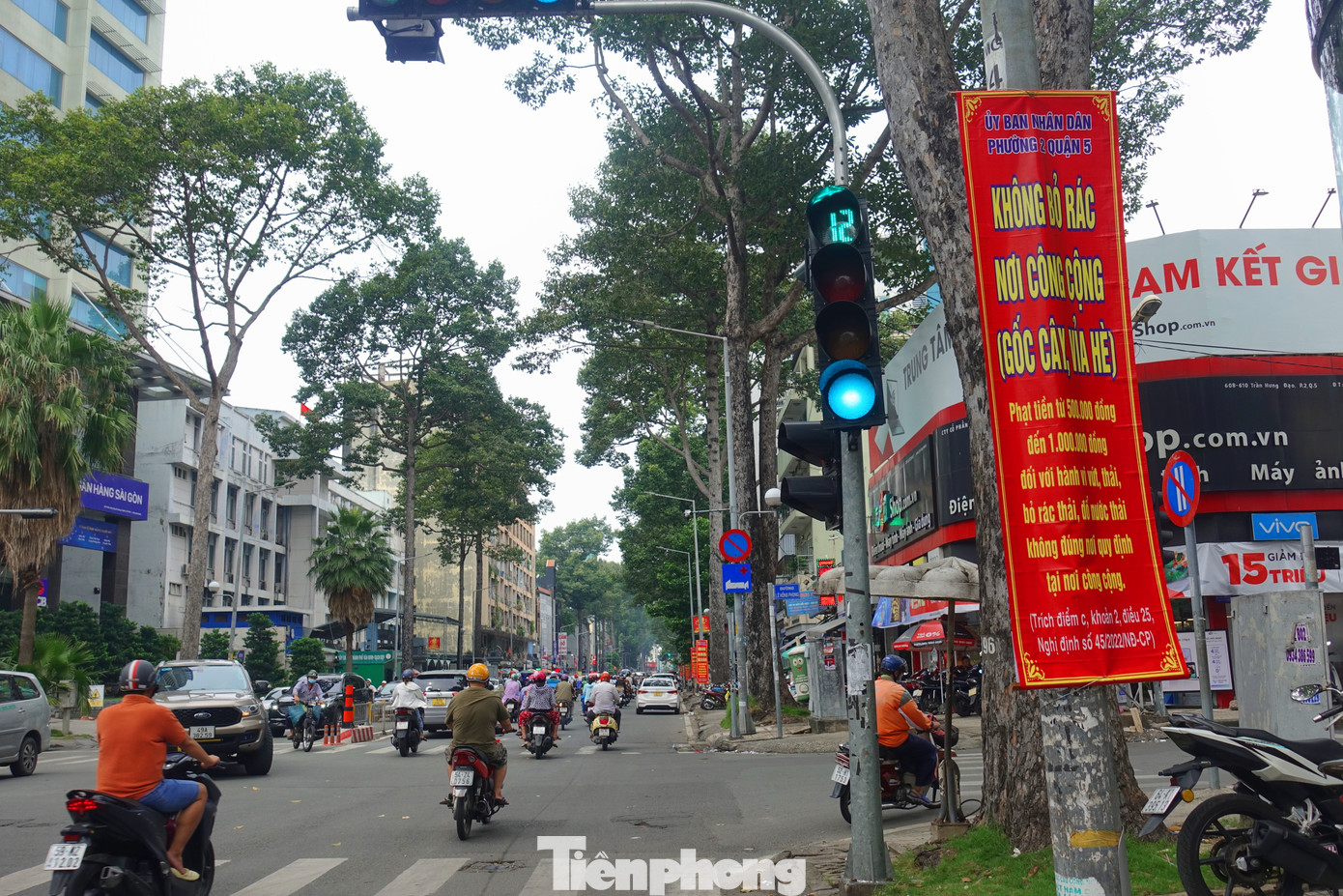Người dân khu vực cho biết, việc tháo gỡ các tấm cỏ nhựa, cỏ nhân tạo đã được cơ quan chức năng địa phương thực hiện từ ngày hôm qua (22/9). Trong ảnh: Một số trụ đèn chiếu sáng trên đường Trần Hưng Đạo (phường 2, quận 5) đã được tháo tấm cỏ nhựa và treo băng rôn yêu cầu không xả rác.