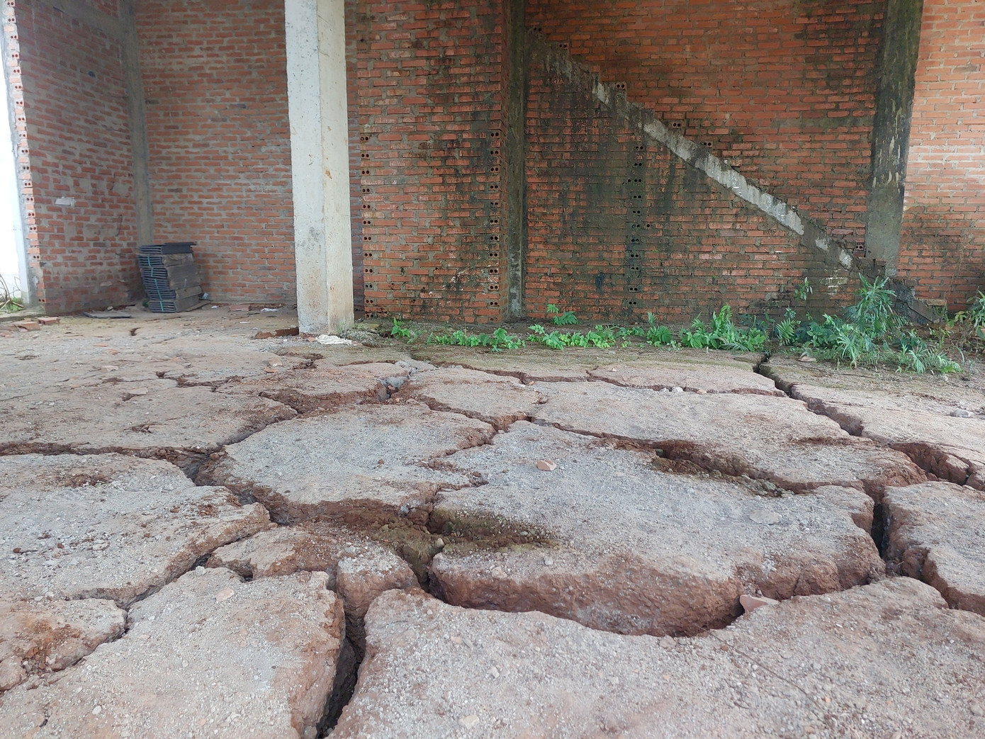 Những căn nhà phố xây xong phần thô bị bỏ mặc. Tường đầy rêu mốc, nền đất vỡ từng mảng Những căn nhà phố xây xong phần thô bị bỏ mặc. Tường đầy rêu mốc, nền đất vỡ từng mảng