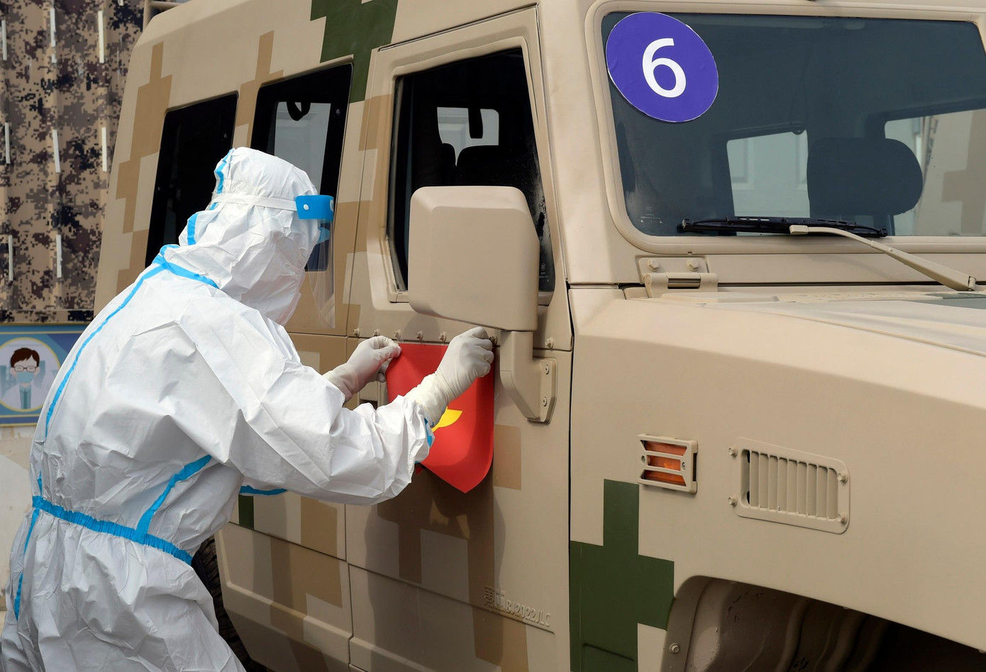 Thành viên Ban Tổ chức dán cờ Việt Nam lên xe Đội tuyển Hóa học QĐND Việt Nam vừa bốc thăm.