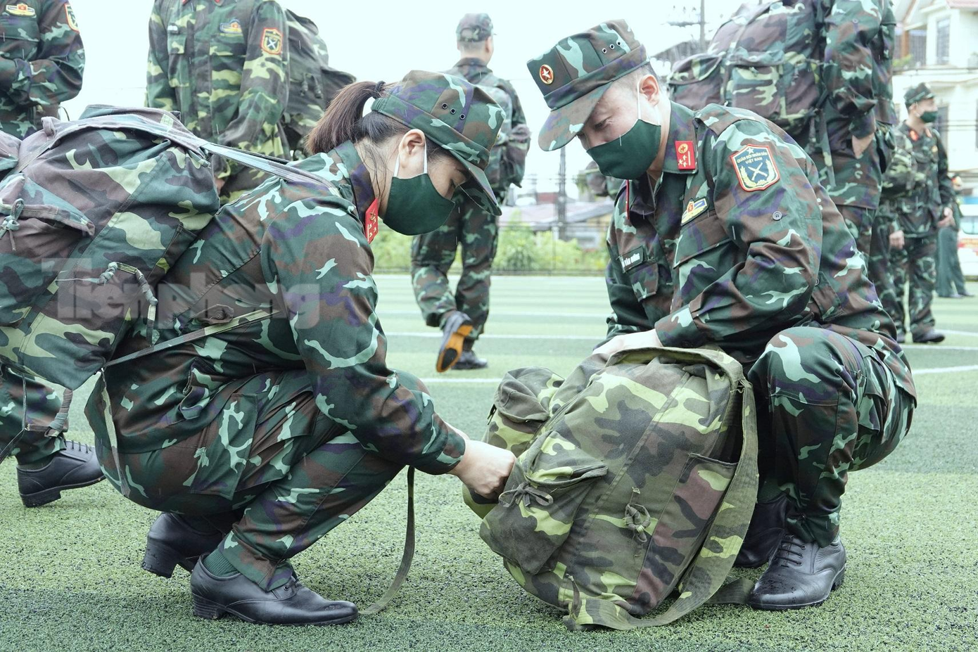 Đại úy QNCN Vũ Thị Hậu giúp đồng nghiệp ở Bệnh viện Quân y 105 là Thượng úy QNCN Đỗ Văn Cường gói buộc quân trang trước giờ hành quân, sáng 1/8. Ảnh: Nguyễn Minh