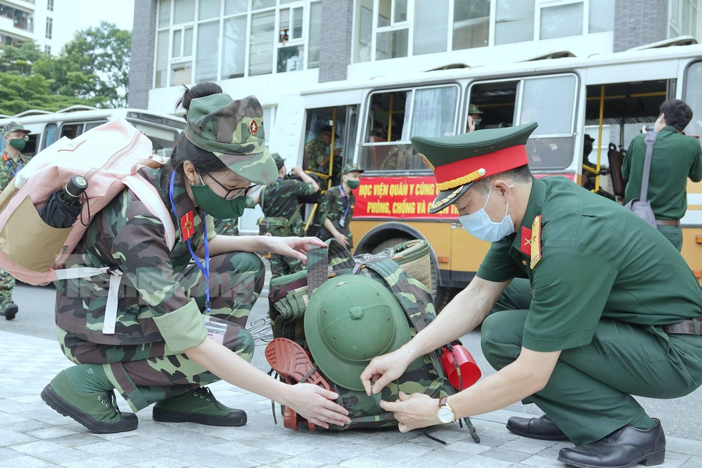 Sĩ quan Học viện Quân y giúp nữ học viên gói buộc quân trang trước giờ ra sân bay. Ảnh: Nguyễn Minh