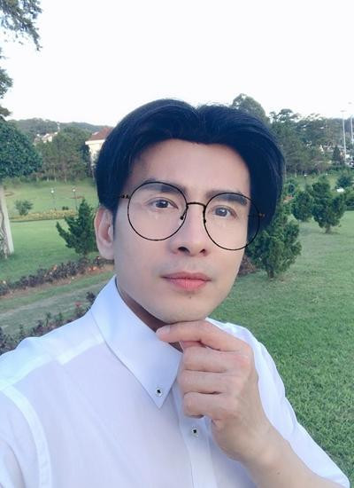 Đan Trường như cậu sinh viên khi mặc sơ mi trắng, đeo mắt kính.