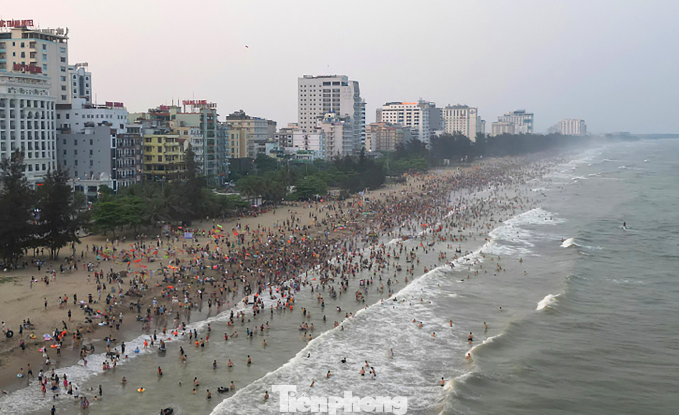 Giữa cái nắng nóng đầu hè, hàng vạn du khách và người dân địa phương đổ về Sầm Sơn tắm mát khiến bờ biển đông nghịt.