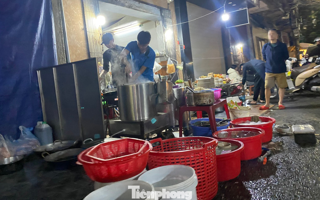 Một cửa hàng ăn trên phố Lê Chân, chủ cơ sở nấu ăn, rửa bát, xả nước rửa bát trực tiếp trên vỉa hè, lòng đường.