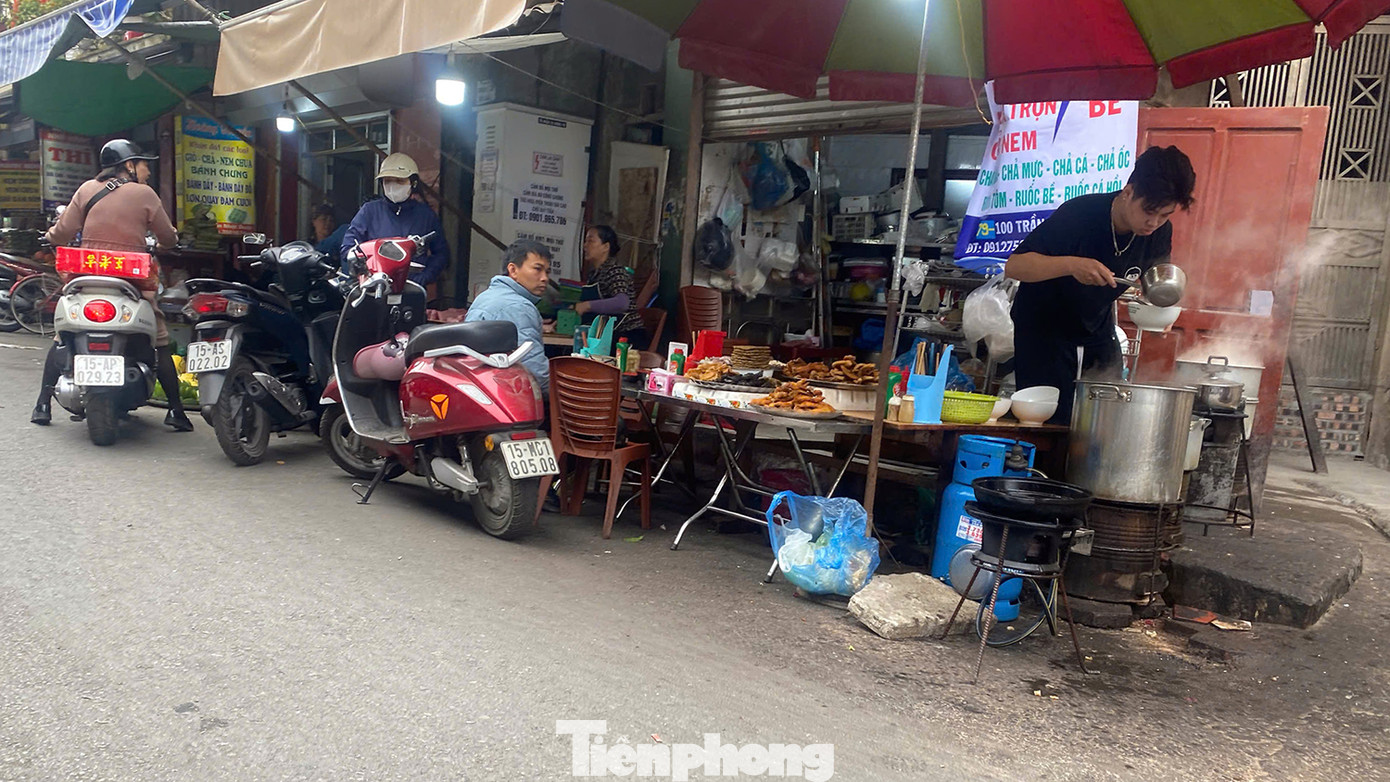 Một cửa hàng chả nem, bánh đa cua trên phố Trần Nhật Duật dùng cả bếp gas, bếp than nấu và bán dưới lòng đường, kế bên là cửa hàng thịt lợn.