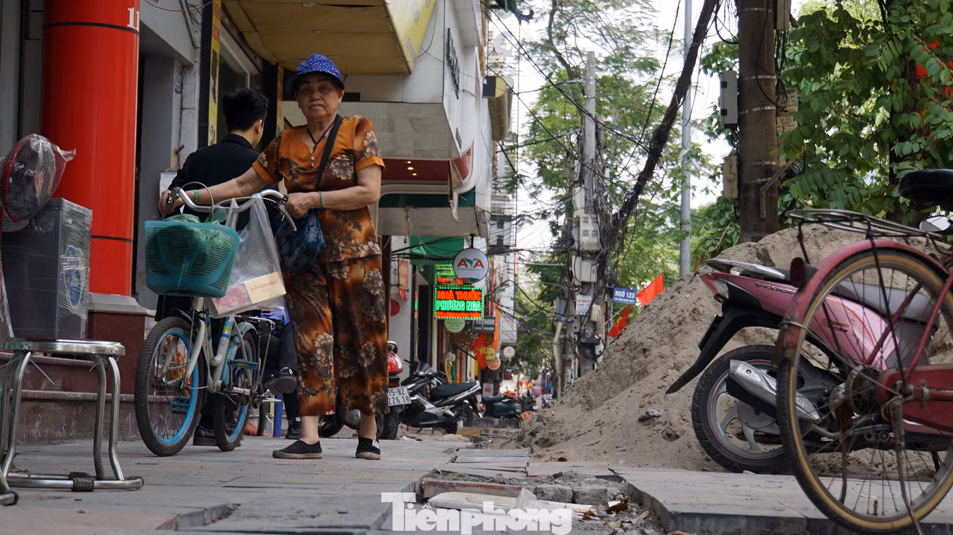 Do vật liệu ngổn ngang, đá lát dở dang trên vỉa hè khiến người dân cũng không còn lối đi bộ.