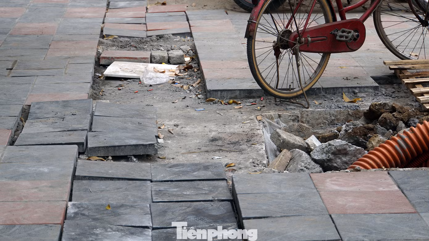 Do vật liệu ngổn ngang, đá lát dở dang trên vỉa hè khiến người dân cũng không còn lối đi bộ.