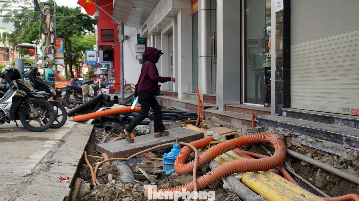 Các hộ dân, hộ kinh doanh đặt ván gỗ hoặc các vật liệu bắc cầu từ lòng đường vào nhà, phía dưới là hệ thống đường điện, cáp viễn thông, cống thoát nước... Các hộ dân, hộ kinh doanh đặt ván gỗ hoặc các vật liệu bắc cầu từ lòng đường vào nhà, phía dưới là hệ thống đường điện, cáp viễn thông, cống thoát nước...