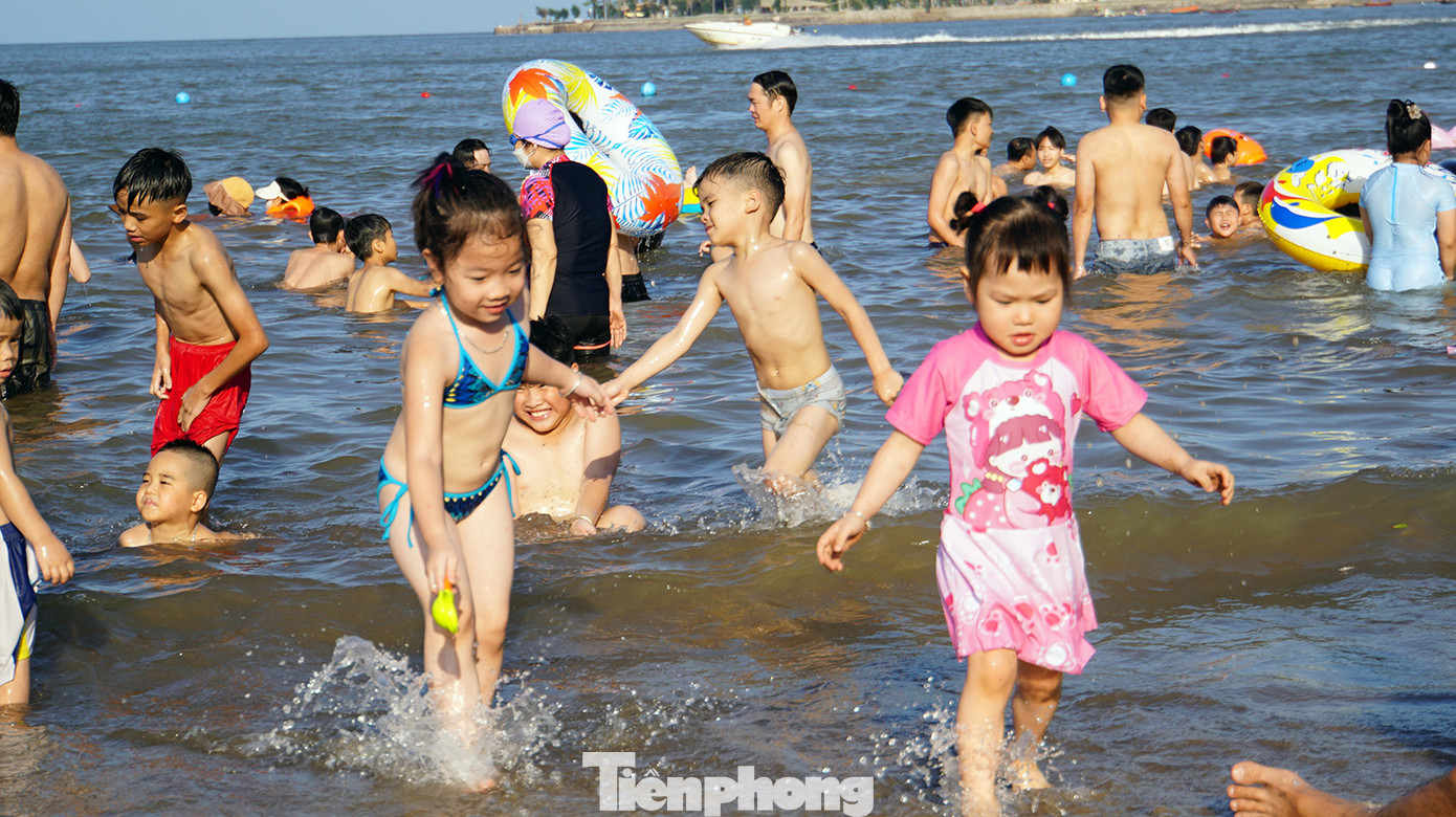 Các em nhỏ nô đùa bên bờ cát, ôm phao tắm biển. Các em nhỏ nô đùa bên bờ cát, ôm phao tắm biển.