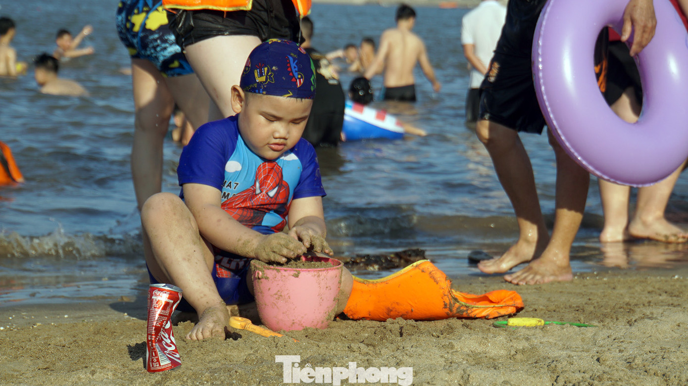 Các em nhỏ nô đùa bên bờ cát, ôm phao tắm biển. Các em nhỏ nô đùa bên bờ cát, ôm phao tắm biển.