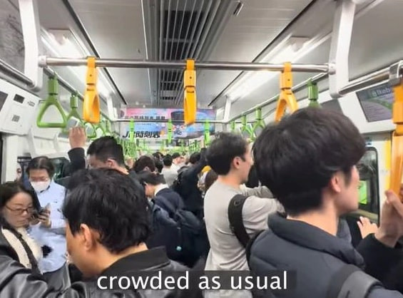Chen chân trên chuyến tàu đông đúc để đến nơi làm việc. Ảnh: News