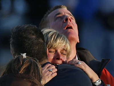 Gia đình nạn nhân đau khổ gần trường Sandy Hook. Ảnh: GETTY IMAGES
