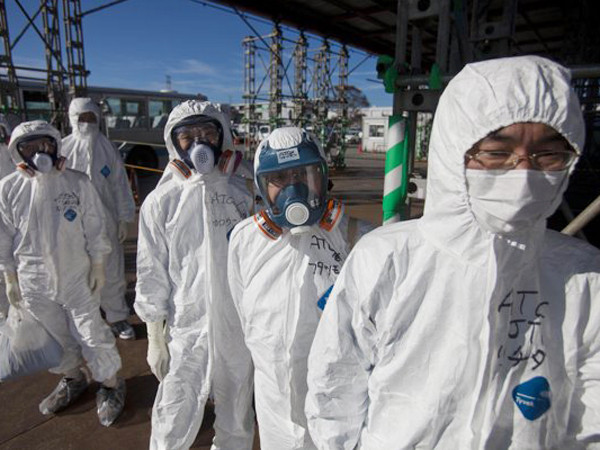 Các phóng viên thị sát nhà máy trong trang phục kín từ đầu đến chân