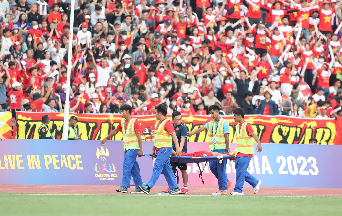 Văn Khang phải nằm cáng rời sân. Ảnh: Hữu Phạm