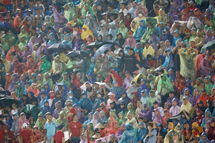 Người hâm mộ đội mưa xem Việt Nam thi đấu. Ảnh: Như Ý
