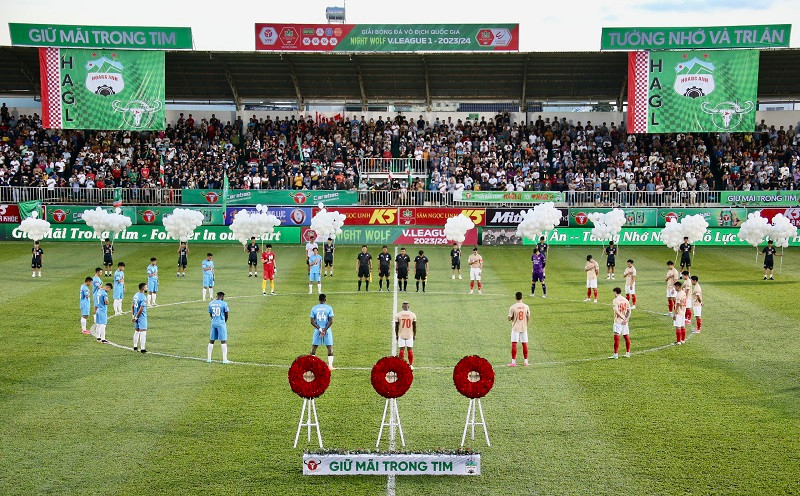 Các cầu thủ và cổ động viên thực hiện 1 phút tưởng niệm các nạn nhân. Ảnh: Dư Hải